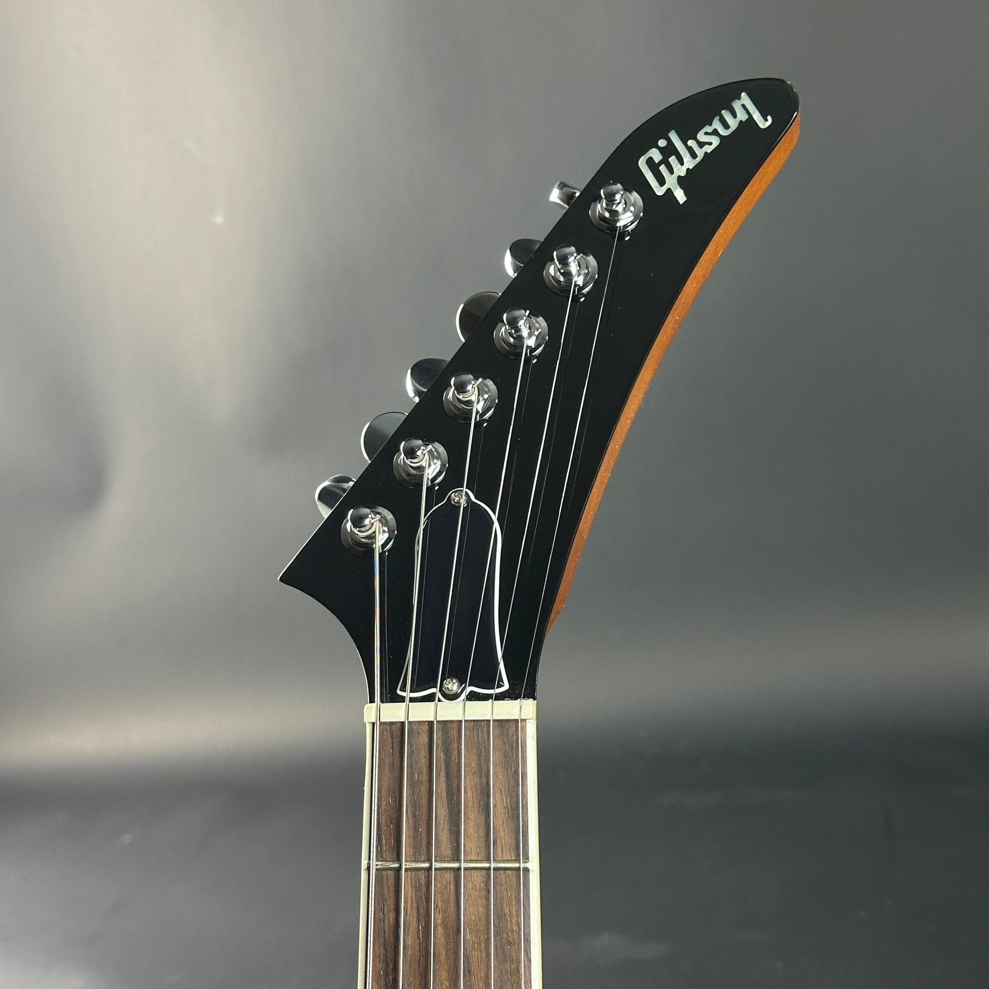 Gibson guitar headstock on a gray background