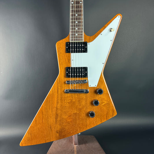Wooden electric guitar with a unique body shape on a gray background