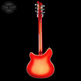 A classic electric guitar shown from the back, featuring a vibrant red-to-orange sunburst finish against a solid black background. The headstock is visible at the top, and a 'TONE SHOP' watermark is in the upper left corner.
