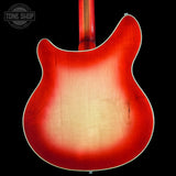 Close-up of the back of an electric guitar showing a classic sunburst finish that fades from bright red to a natural light wood tone. The neck is visible at the top center against a solid black background.