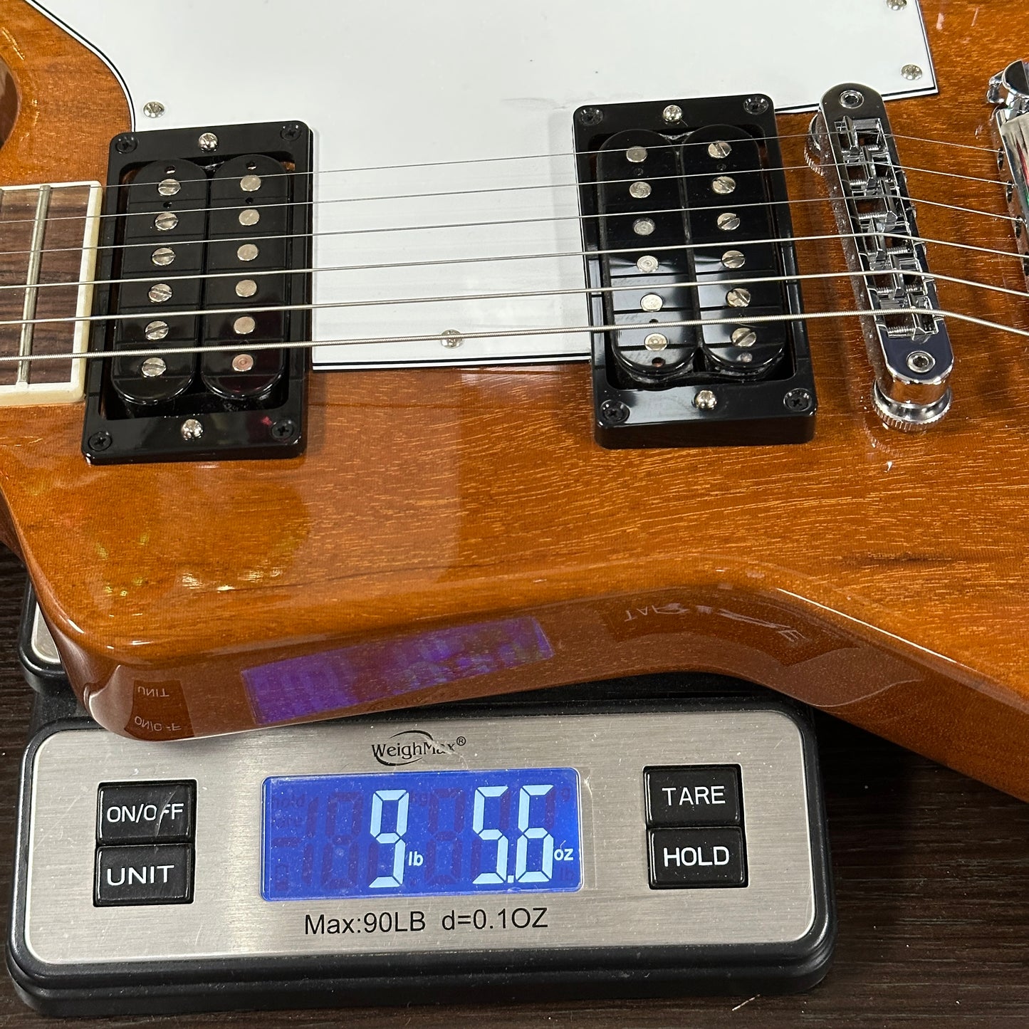 Guitar on a digital scale displaying weight