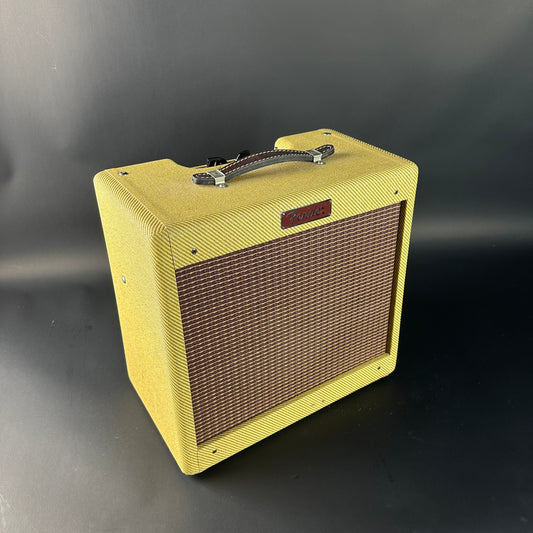 Yellow guitar amplifier with brown grille on a black background