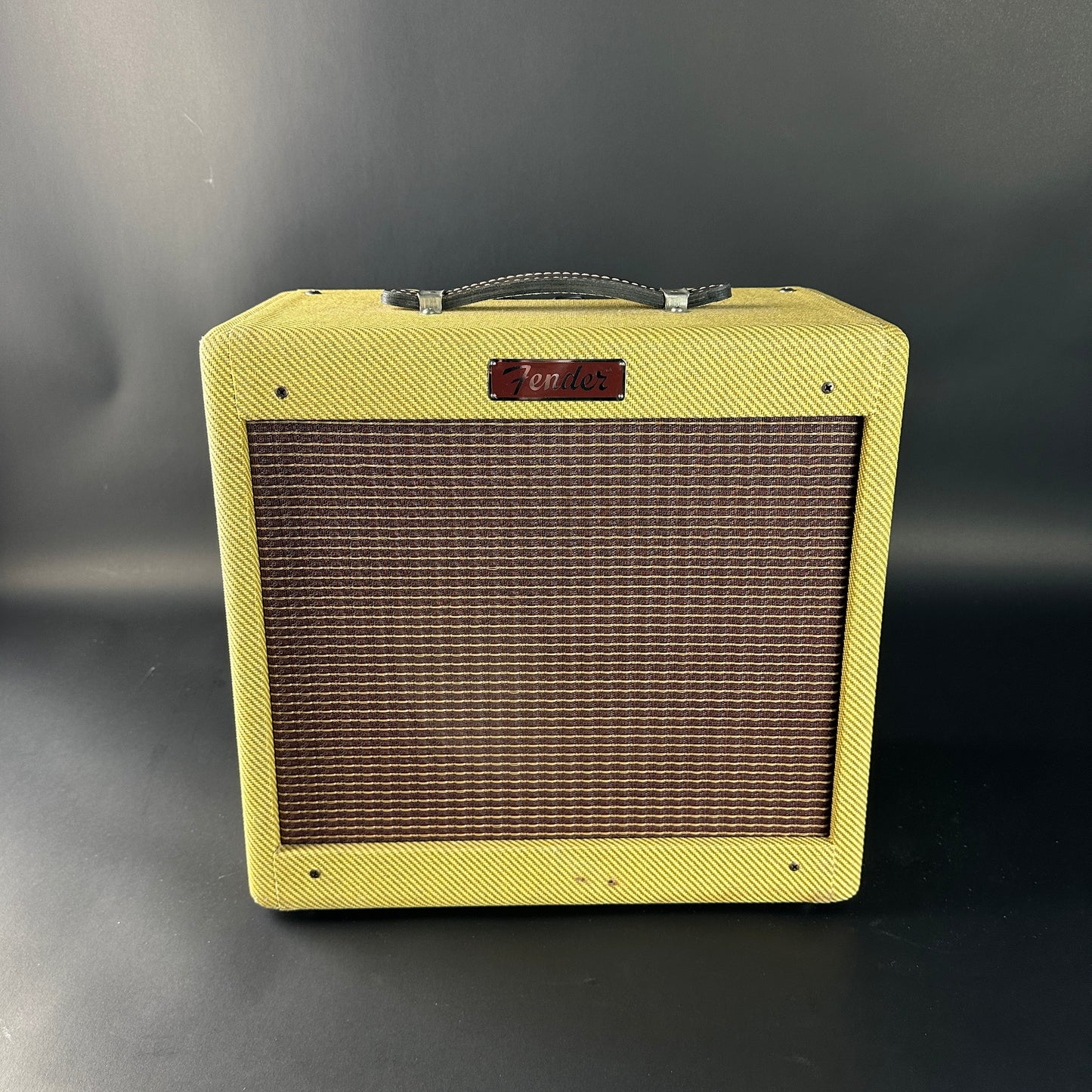 Vintage-style guitar amplifier with a textured yellow exterior on a gray background