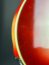 Close-up detail of an electric guitar body showing the sunburst finish, edge trim, and part of the control knob against a dark background.