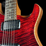 Close-up of a red electric guitar with a black pickguard on a black background