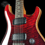 Close-up of a red electric guitar with a black background