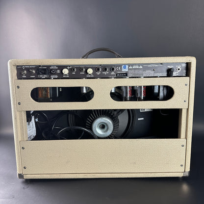 Beige guitar amplifier with visible components on a gray background