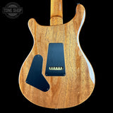 Wooden electric guitar body with control panel on a black background, featuring 'Tone Shop' logo.