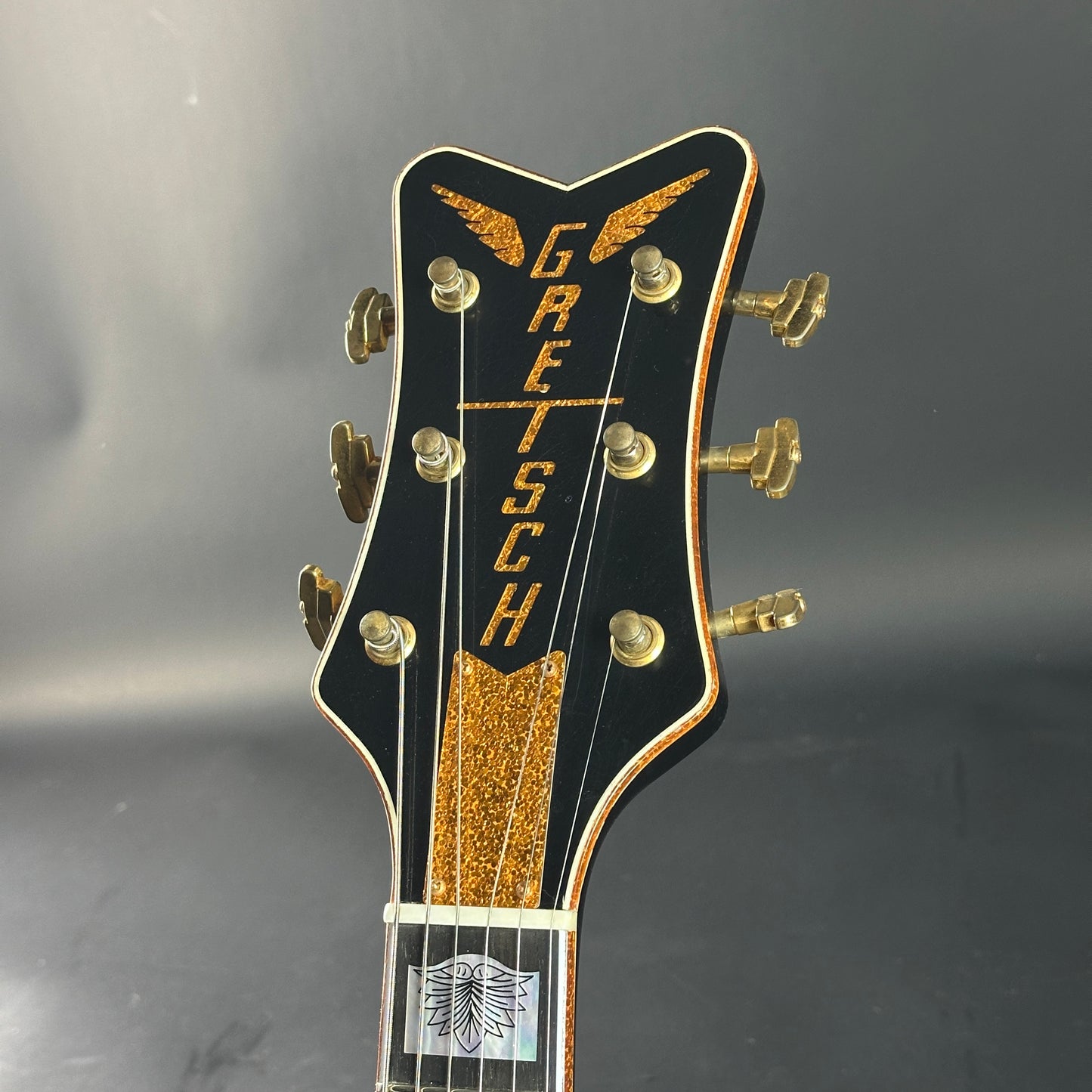 Gretsch guitar headstock on a gray background