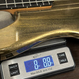 Ernie Ball Music Man 50th Anniversary StingRay Molten Gold on scale displaying weight.
