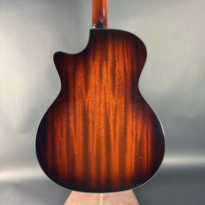 Back view of a guitar with a brown finish on a gray background