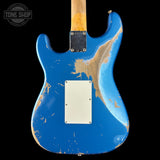 The back of a blue electric guitar body with a heavily distressed, worn finish showing the wood underneath, a white pickguard, and a black hardware plate, set against a solid black background.