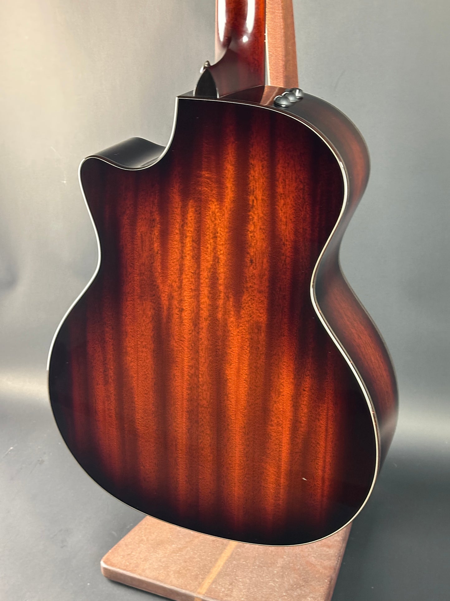 Close-up of a guitar's wooden body on a gray background