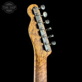 Close-up of the headstock of an electric guitar with a natural figured burl wood finish and silver tuning pegs, shown against a solid black background with a Tone Shop watermark in the top left corner.