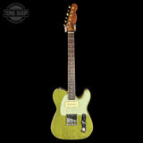 A glittery gold electric guitar with a cream pickguard and maple headstock, shown against a solid black background with a Tone Shop watermark in the top-left corner.