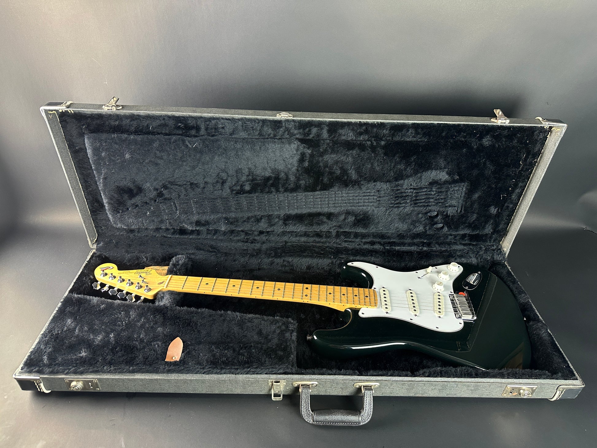 Electric guitar in an open case on a gray background