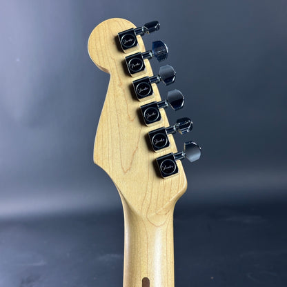 Guitar headstock with tuning pegs on a dark gray background