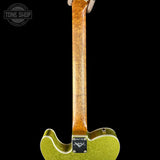 Close-up of the neck and lower body of an electric guitar against a black background, showing a bright yellow-green glitter finish, a natural wood neck, and a Tune Shop logo overlay in the top left.