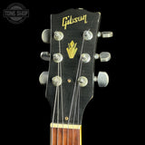 Gibson guitar headstock with brand logo on a black background