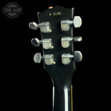 Guitar headstock with tuning pegs on a black background, featuring 'Tone Shop' logo.