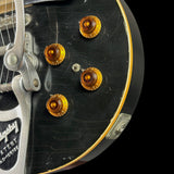 Close-up of a guitar's control knobs with a black background