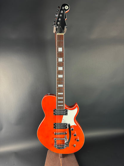 Orange electric guitar on a gray background