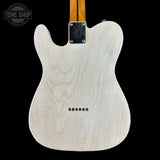The back of a Fender Telecaster electric guitar with a natural ash wood body, shown against a solid black background. A Tone Shop watermark is visible in the top-left corner.