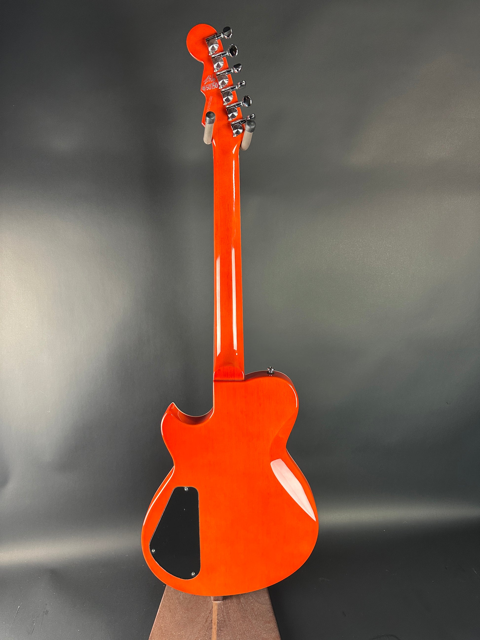 Orange electric guitar on a gray background