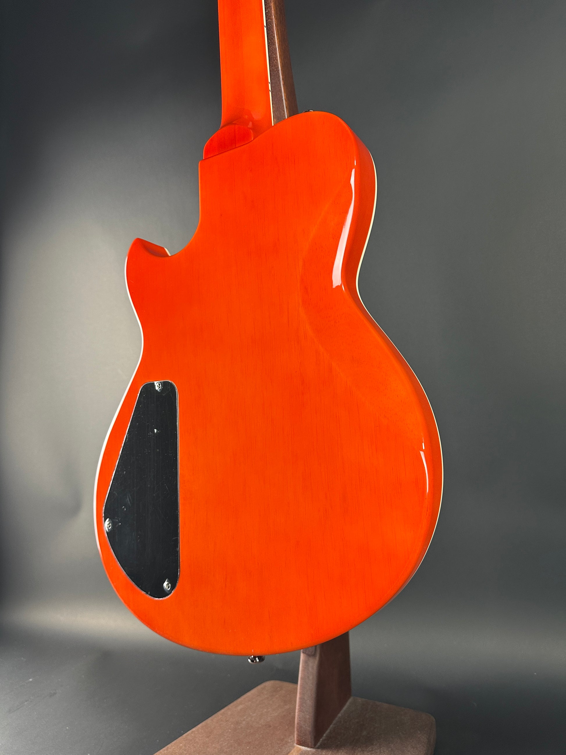 Orange electric guitar body on a gray background