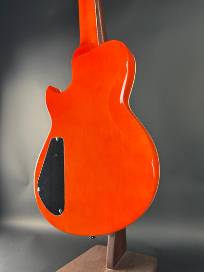 Orange electric guitar body on a gray background
