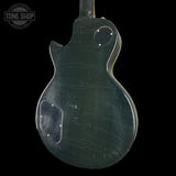 Back view of a green electric guitar with 'Tone Shop' logo.