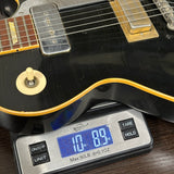Electric guitar on a digital scale displaying weight