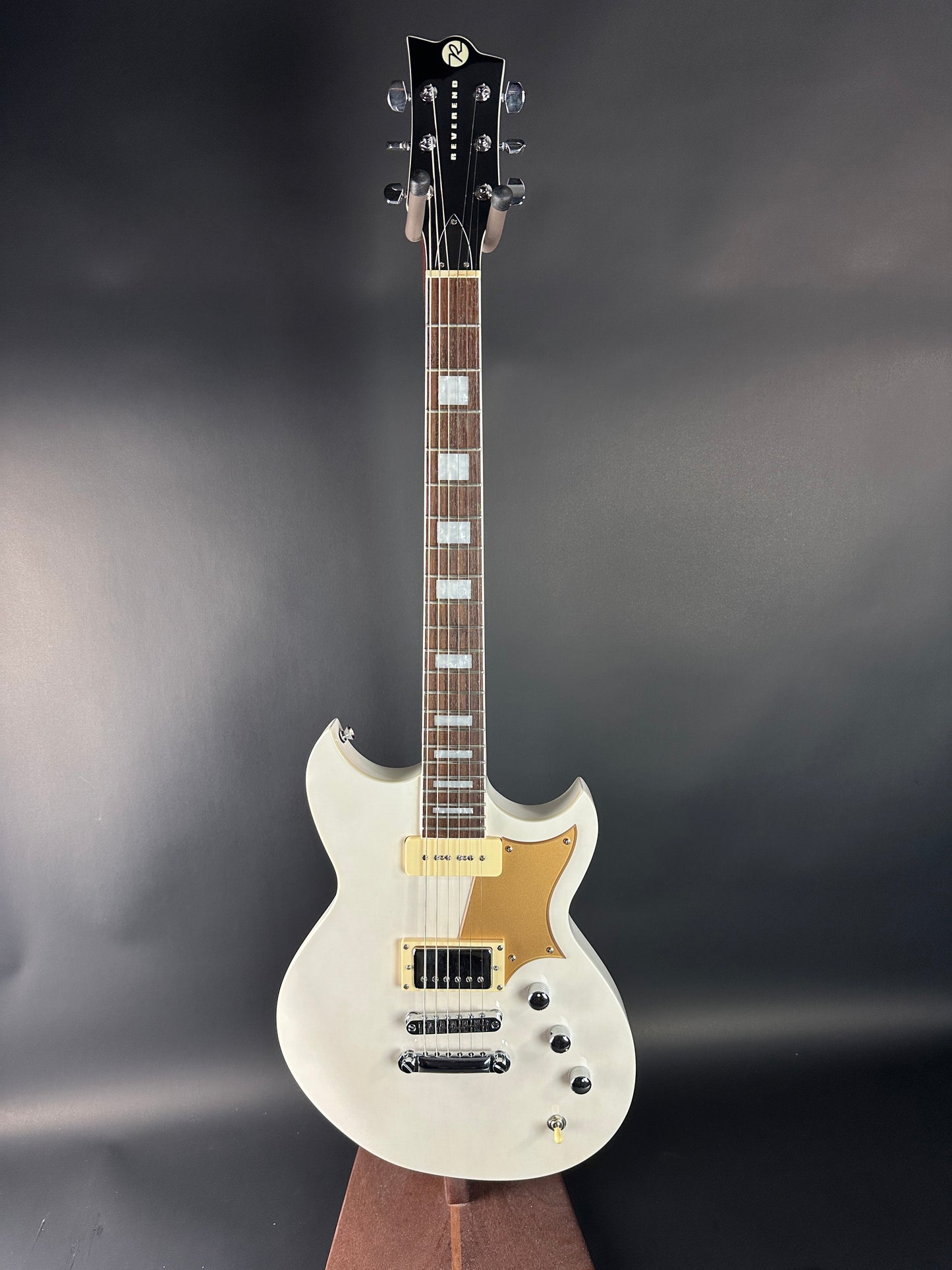 White electric guitar on a dark gray background