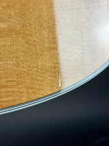Close-up of a guitar body showing two wood finishes: a warm honey-toned natural finish on the left and a light natural wood finish on the right, separated by a glossy edge with a thin black stripe.