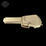 A vintage beige guitar case with a zippered front pocket and a metal tuning key ring, shown against a solid black background with a Tone Shop watermark in the top left corner.