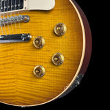 Close-up of a sunburst electric guitar with gold hardware on a black background