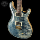 Blue electric guitar with a visible brand logo on a black background
