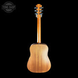 The back view of a wooden acoustic guitar against a solid black background, featuring a warm honey-toned wood finish and a silver tuning pegs on the headstock. A 'TONE SHOP' watermark is visible in the top-left corner.