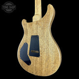 Wooden electric guitar body with 'Tone Shop' logo in the corner