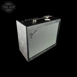A Fender guitar amplifier speaker cabinet with a black textured exterior and a silver-gray front grille, shown at an angle on a solid black background. A Tone Shop watermark is visible in the top-left corner.