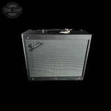 A Fender guitar amplifier cabinet with a black textured grille and silver Fender logo, shown against a solid black background.