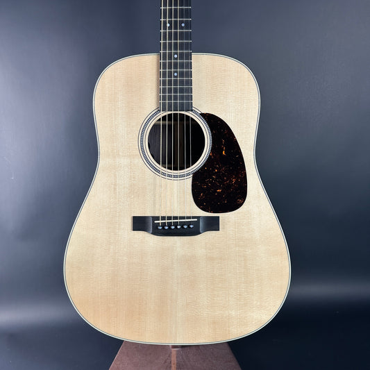 Acoustic guitar with a natural wood finish on a dark background