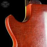 Close-up of a guitar's body with a visible brand logo in the corner.