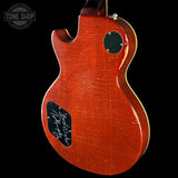 Red electric guitar with a visible brand logo on a black background
