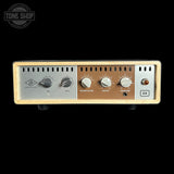 A guitar amplifier head with control knobs on a black background, featuring the Tone Shop logo.