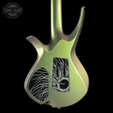 The back of an electric guitar with a metallic iridescent green body, black pickups, and white abstract graphics, shown against a black background with a Tone Shop watermark.