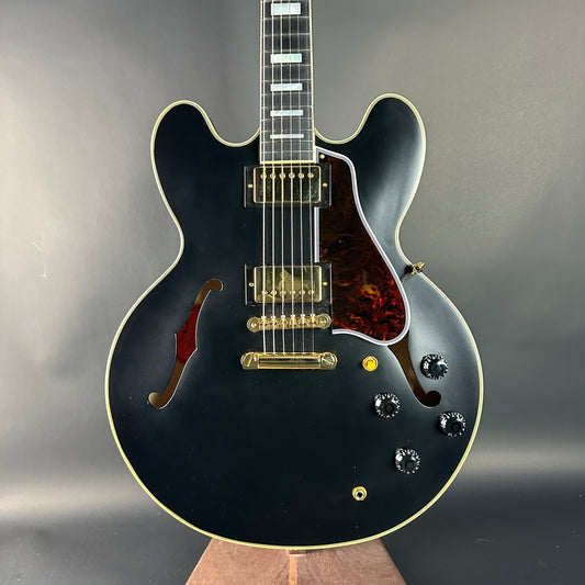 Black electric guitar with a glossy finish on a gray background