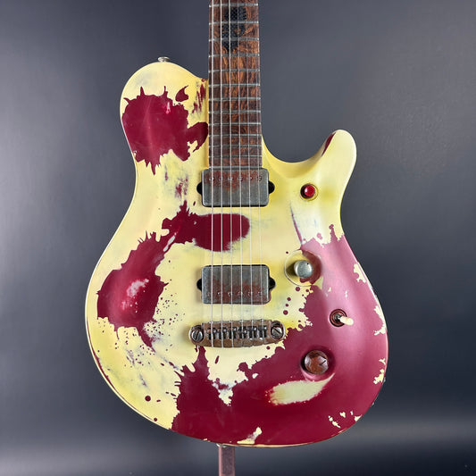 Distressed electric guitar with a marbled design on a dark background