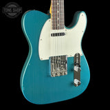 Blue electric guitar with a white pickguard on a black background, featuring 'Tone Shop' branding.