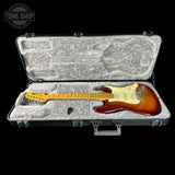 Electric guitar in a hard-shell case with 'Tone Shop' logo.